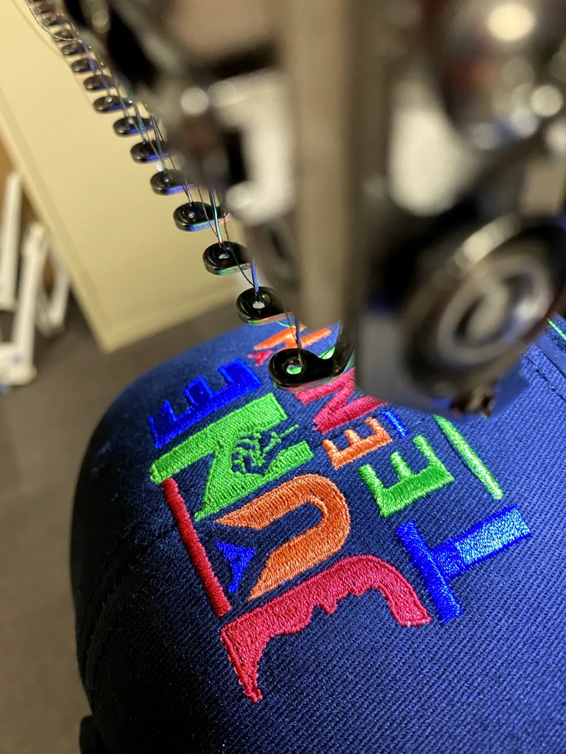 Colorful embroidery in progress on a cap