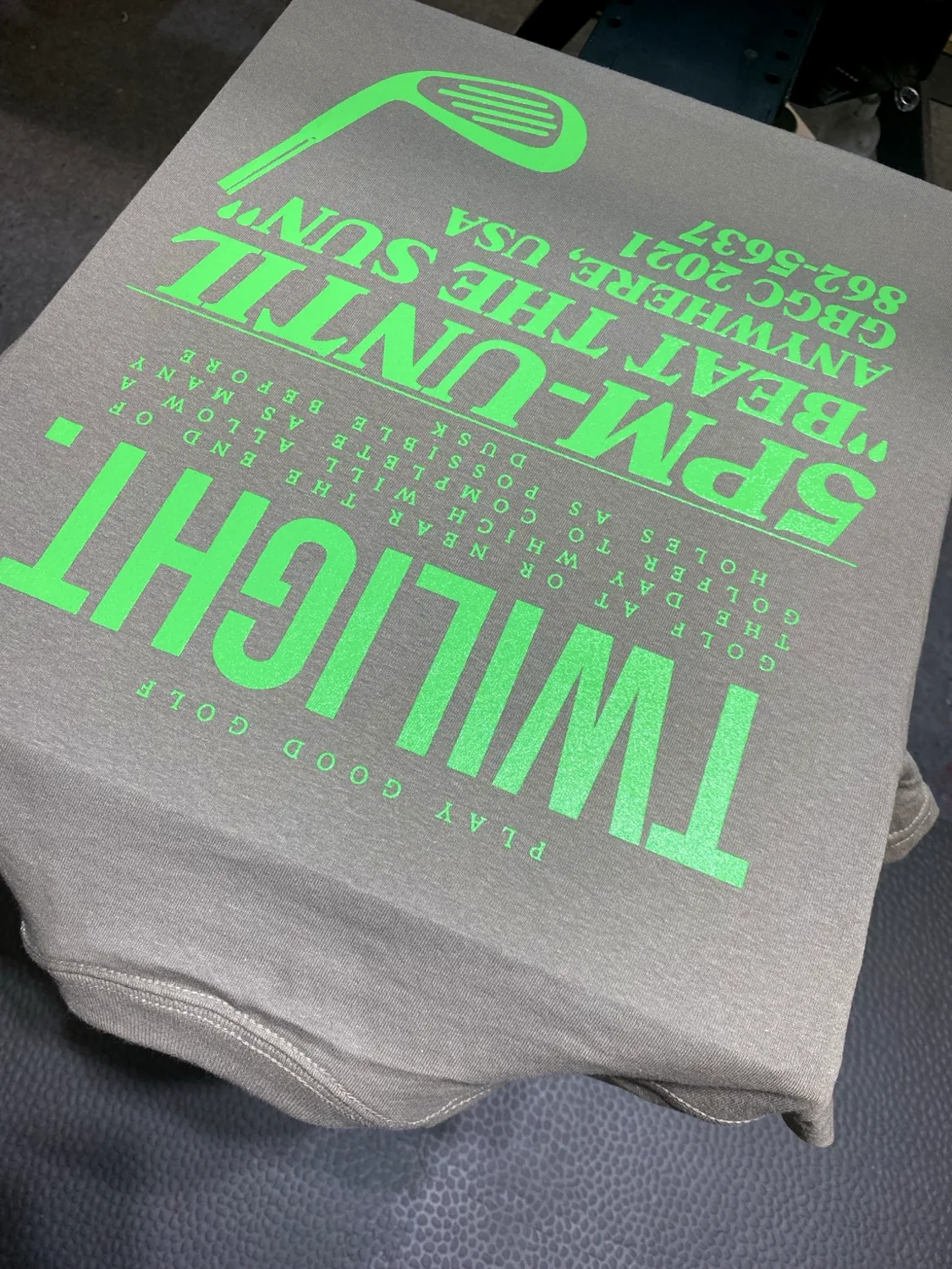 Neon green screen print on gray golf apparel