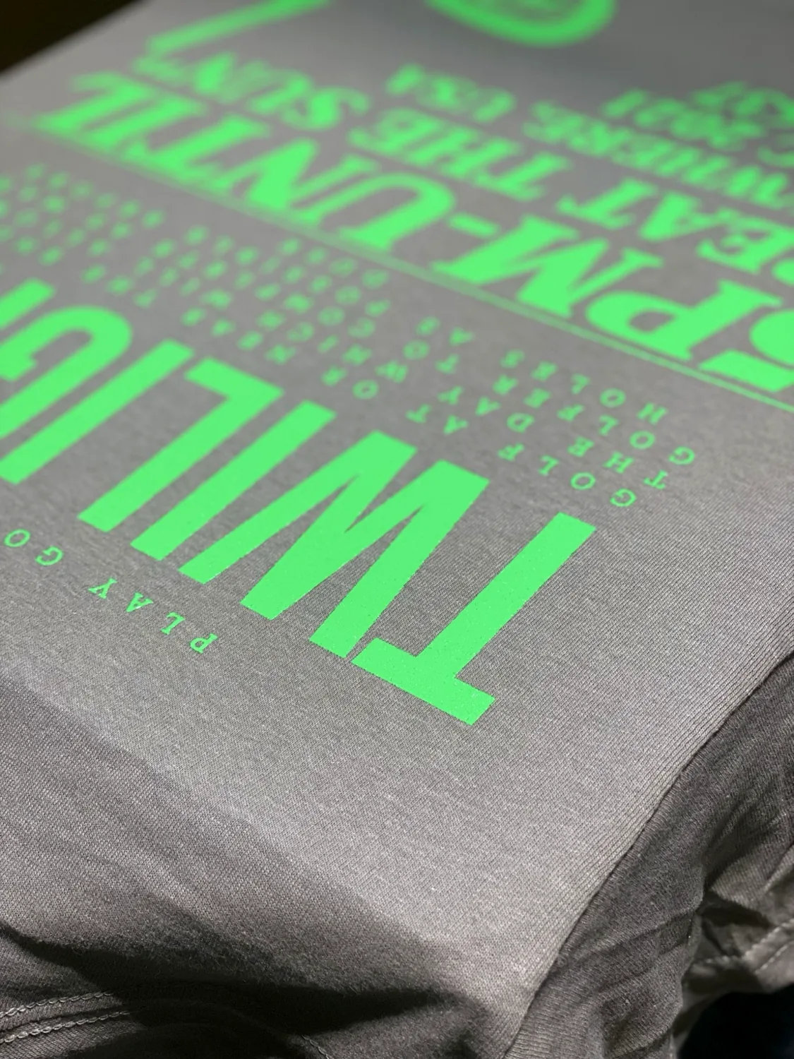 Detail of green screen print on gray shirt