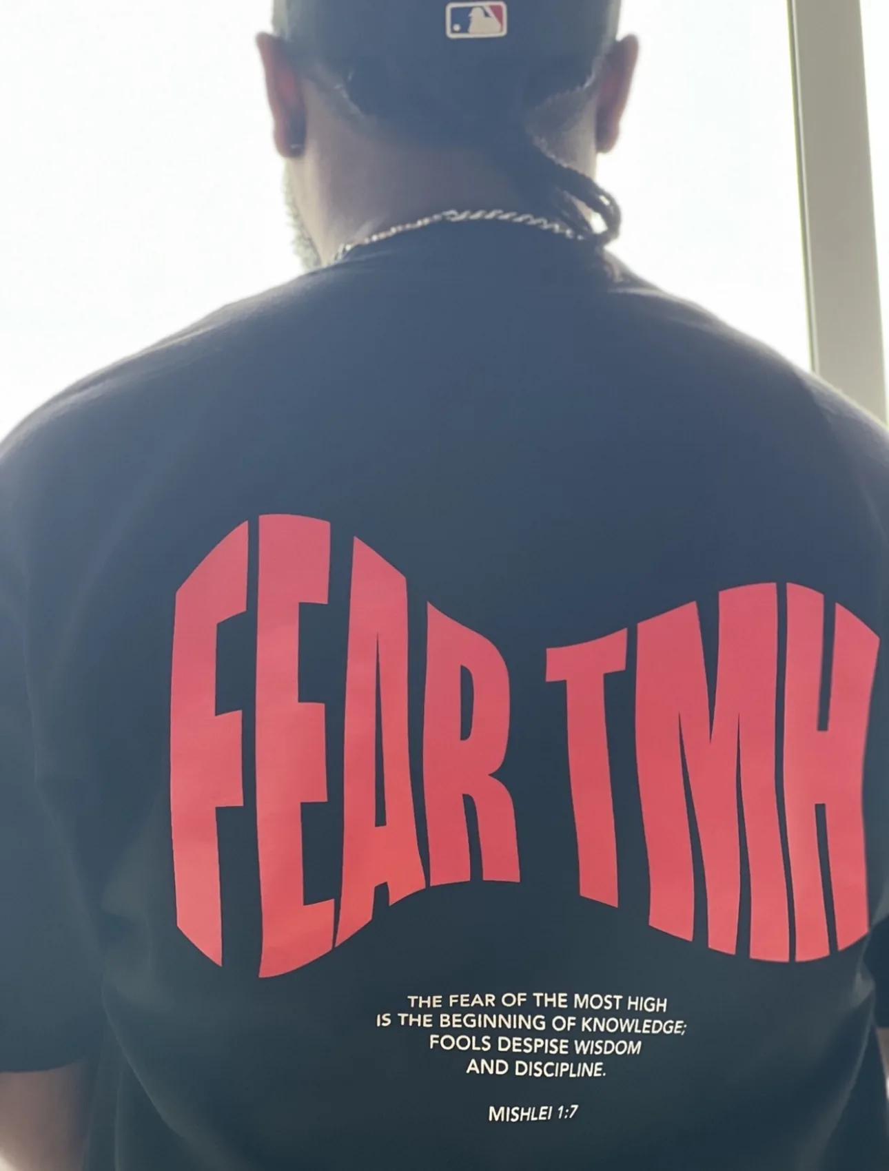 Finished red Fear TMH print on the back of a black shirt being worn